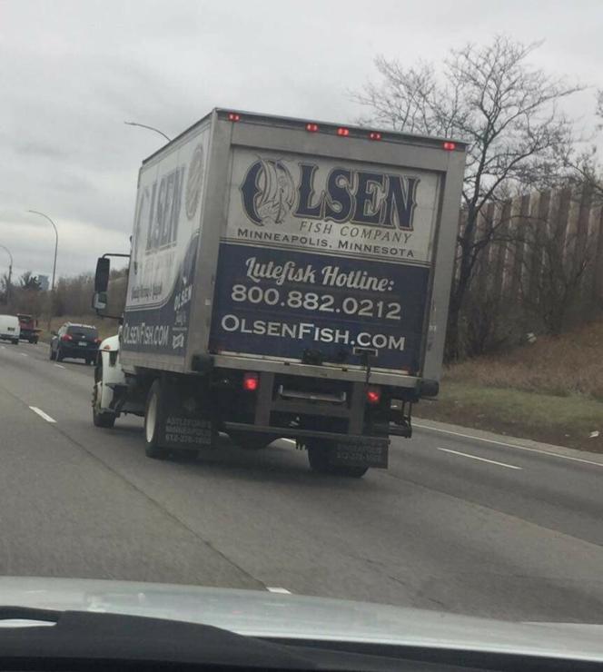 Photo of the Olsen Fish Company truck heading down the highway somewhere in MSP. The back of truck is painted in two tones and says 

OLSEN FISH COMPANY
Lutefisk Hotline
800.882.0212
OlsenFish.com